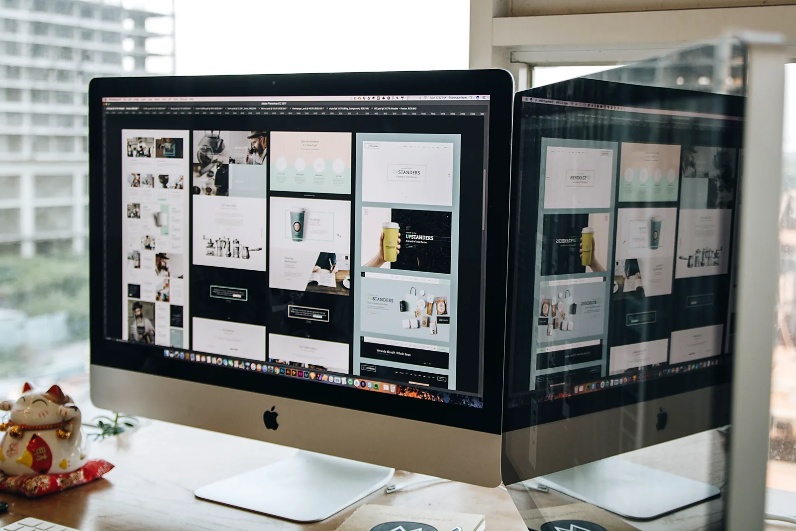 An iMac displaying website design mockups on a desk