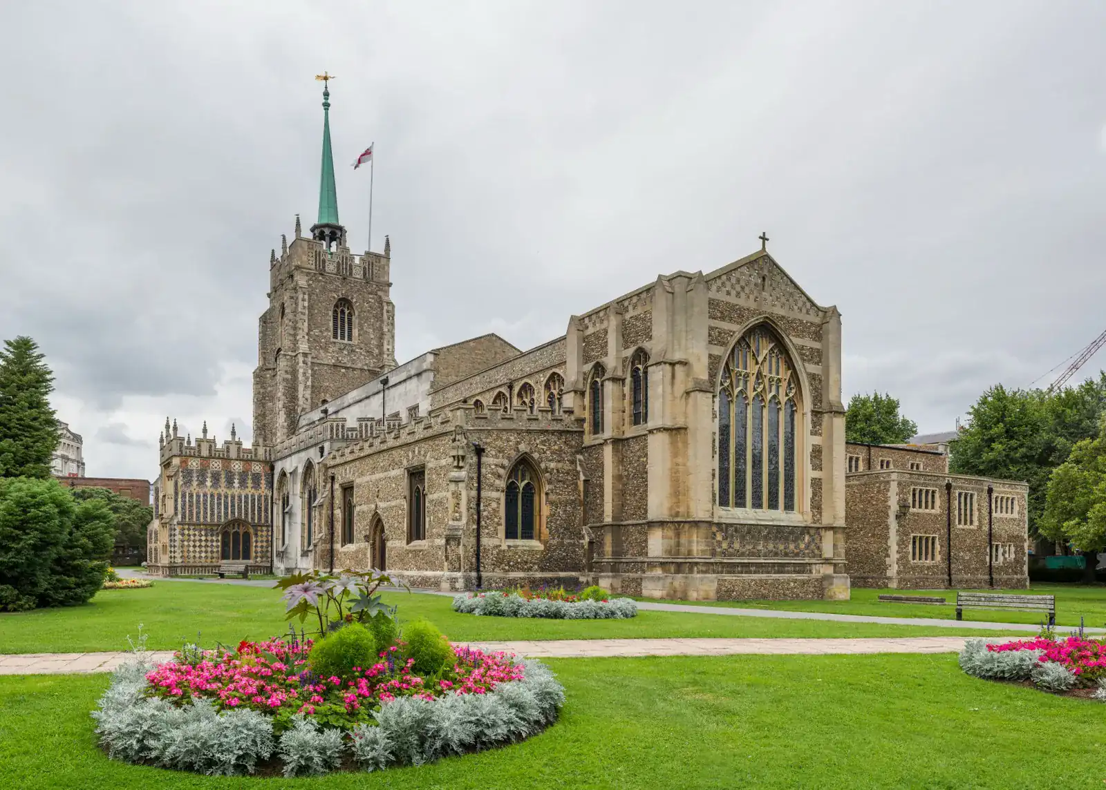 Chelmsford Cathedral seen from the green, a flint and stone church with a spired tower