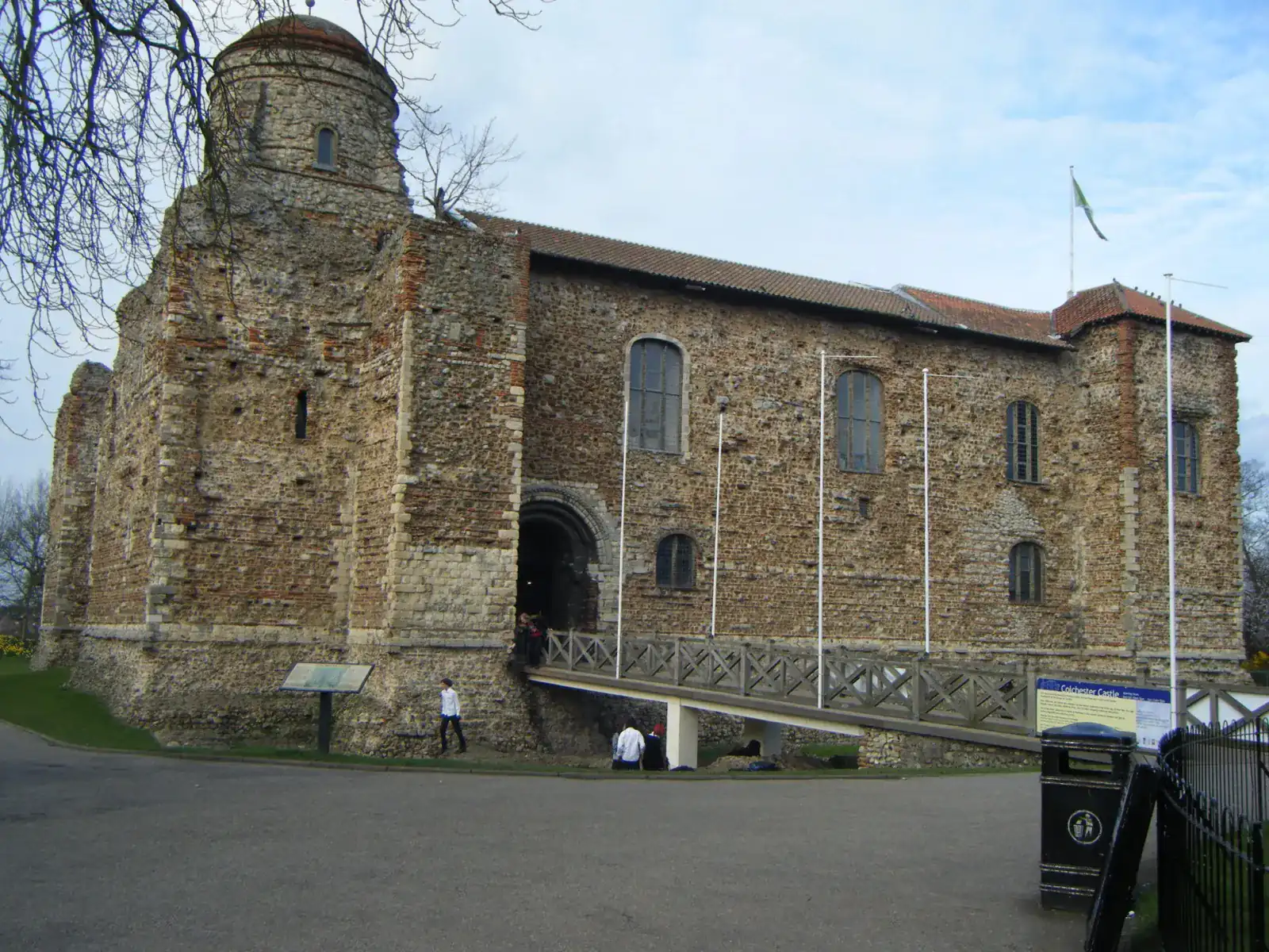 Colchester Castle, a large Norman stone keep with a walkway leading to its entrance