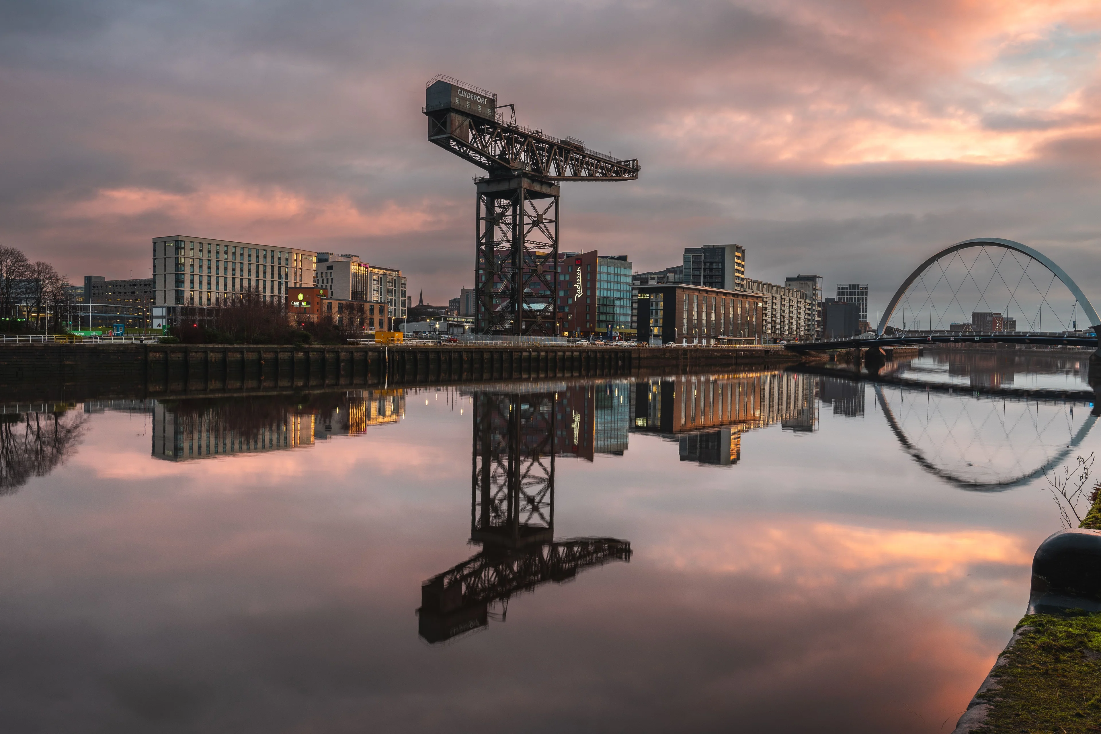 The Finnieston Crane and Clyde Arc bridge reflected in the River Clyde in Glasgow at sunset