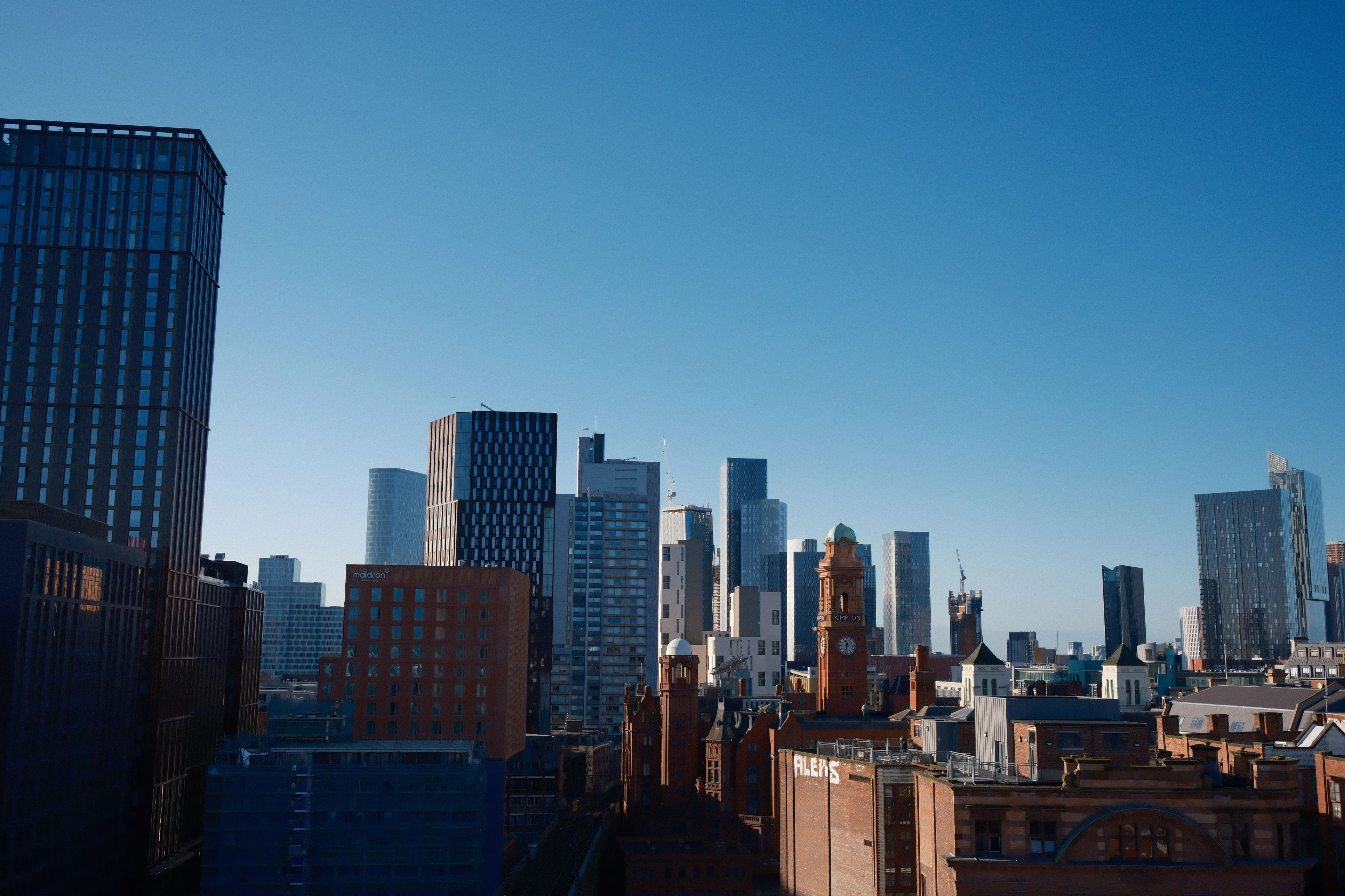 Manchester city centre skyline with the Deansgate Square towers rising behind Victorian red-brick rooftops