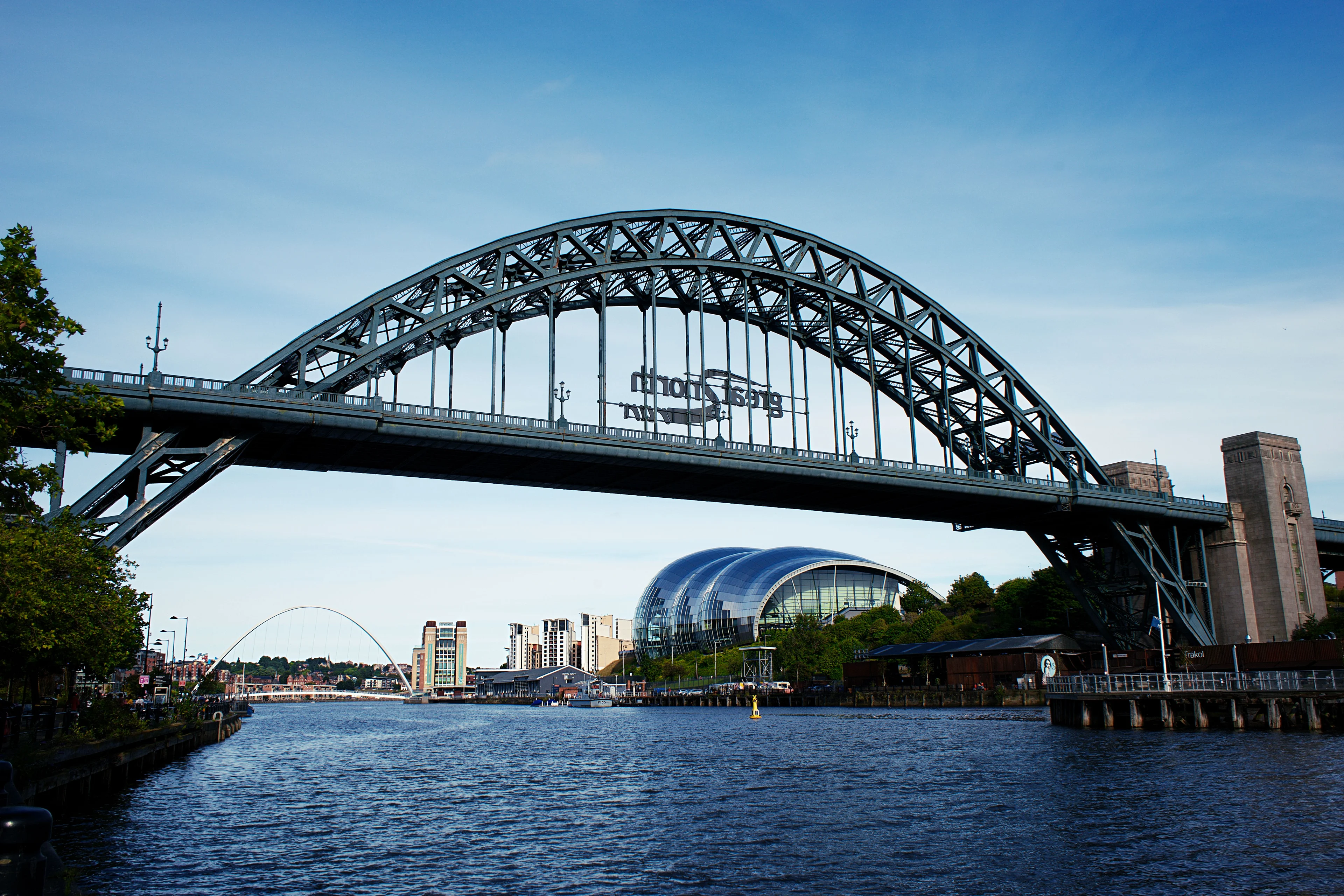 The Tyne Bridge spanning the River Tyne with the Sage Gateshead and quayside buildings behind